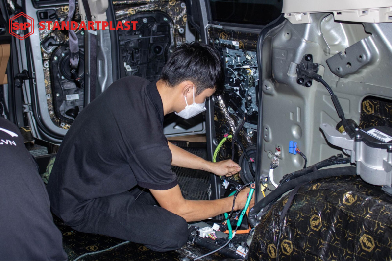 Kỹ thuật viên thi công cẩn thận trong quá trình dán cách âm ô tô